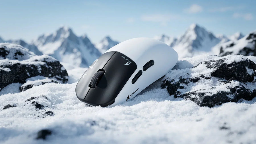 Attack Shark F1 Air wireless gaming mouse resting on snow‑covered rocks with snow mountain background